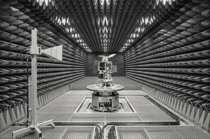 Antenna and test article inside an anechoic chamber lined with foam cones